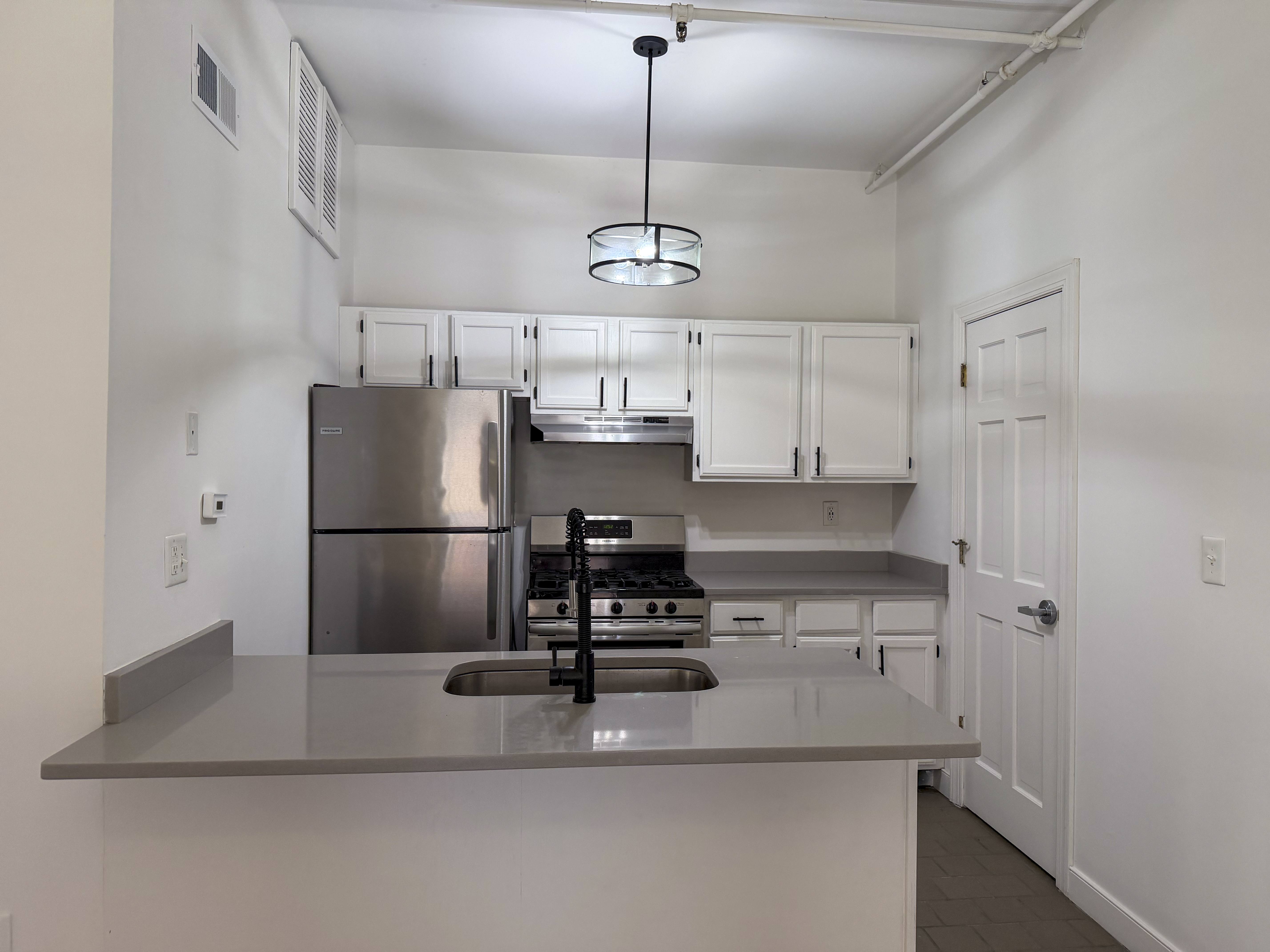 A modern kitchen with stainless steel appliances and white cabinets.
